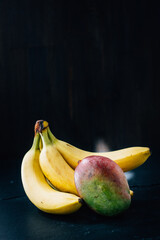 Canvas Print - Mango and banana fruits on a black background