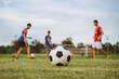 © nateejindakum - Action sport outdoors of a group of kids having fun playing soccer football for exercise in community rural area under the twilight sunset.