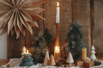 christmas advent. burning christmas candles, trees, paper star on rustic background. happy holidays