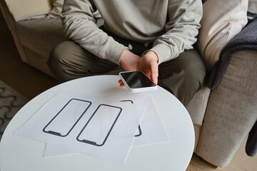 Designer is developing a UX mobile application wireframe. Sketch, prototype, framework, layout future app design for smartphone. UI/UX - user interface and user experience designer. App development