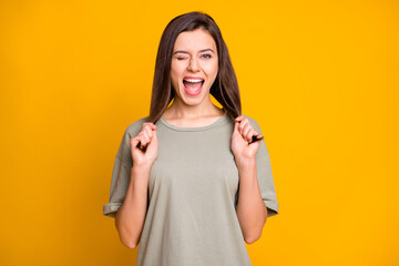 Sticker - Portrait of lovely cheerful funny brown-haired girl winking making tails having fun isolated over bright yellow color background