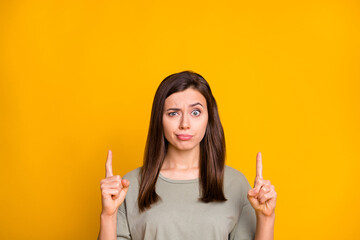 Poster - Portrait of lovely confused skeptic brown-haired girl demonstrating up copy empty place space isolated over bright yellow color background