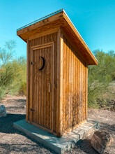 Old Fashion Country Outhouse With Slanted Tin Roof And Moon Shaped Window