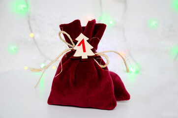 Small bags of gifts surprises, advent calendar on white background with bokeh . Happy waiting of Christmas and New Year.