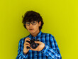 Enthusiastic arab teen photographer with analog slr camera on green background. Selective focus 