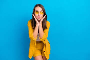 Poster - Photo of young girl pouted lips send air kiss look empty space romantic isolated over blue color background