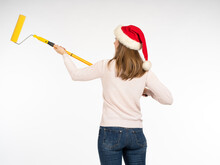 Christmas Woman Isolated. Girl With Paint Roller. Christmas Woman Draws On Stin. Concept Person Is Drawing Christmas Ad. Girl Painter In Santaclaus Hat. Woman With Back To Camera On White