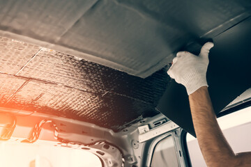 Wall Mural - Worker hands glues soundproofing material to inside of car roof. Process of car sound insulation installation.