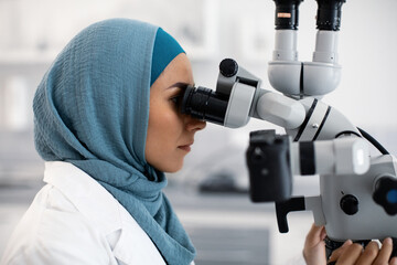 Poster - Muslim Female Dentist Doctor Using Dental Microscope At Workplace In Modern Clinic