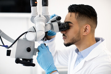 Poster - Young Arab Dentist Doctor Using Dental Microscope At Workplace In Clinic