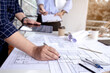 © Anucha - Engineer work environment, Engineers are reading blueprints and calculating professionally.