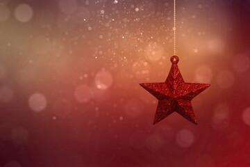 Wall Mural - Red Christmas star hanging with a blurred light background