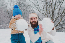 Winter, Father And Son Play Outdoor. Enjoying Nature Wintertime. Winter Portrait Of Dad And Child In Snow Garden. Father And Son Making Snowball On Winter Background.