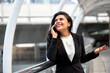 © Atstock Productions - Smiling young Hispanic business woman talking on mobile phone outdoors in the city