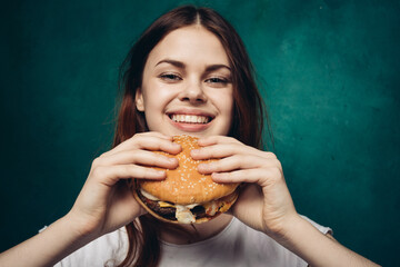 Wall Mural - woman eating hamburger fast food snack close-up