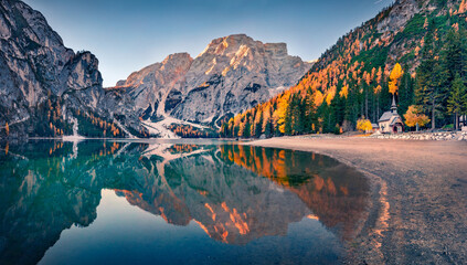 Wall Mural - small chapel on the shore of braies lake. wonderful autumn scene of dolomite alps, naturpark fanes-s