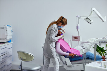 Wall Mural - African woman having her teeth examined by her dentist