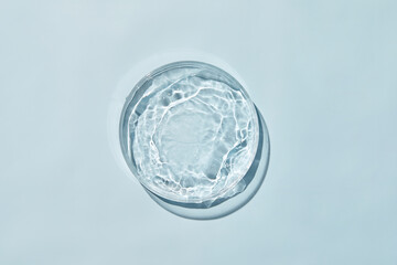 Petri dish with water and ripple in blue background