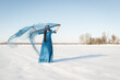 © Milou Dirks - fine art portrait of woman in blue dress standing in cold white snowy winter landscape