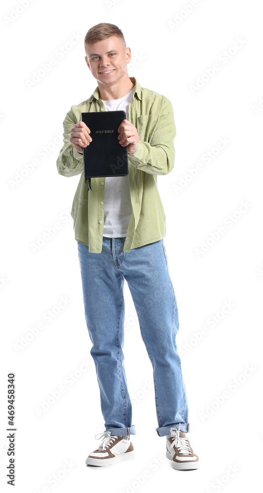 Handsome young man with Holy Bible on white background