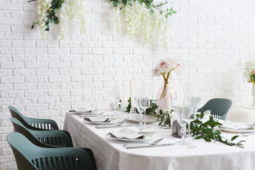 Beautiful table setting for wedding celebration with burning candles in restaurant