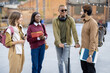 © rh2010 - Smiling multiracial students walk together at university campus. Concept of education and learning. Student lifestyle and friendship. Black man riding electric scooter. Idea of modern transportation