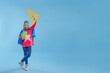 © lithiumphoto - Little girl wearing super hero costume pointing up on blue background