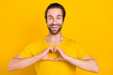 Sticker - Photo of young excited guy demonstrate fingers little heart shape romantic isolated over yellow color background