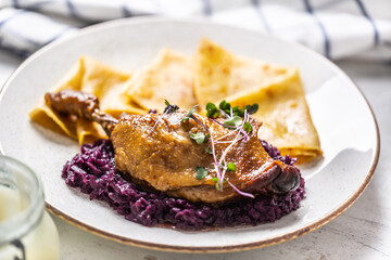 Wall Mural - Portion of duck leg with red cabbage and potato pancakes, a traditional autumn dish in Eastern Europe