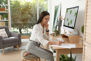 Wall Mural - Young woman working at table in light room. Home office