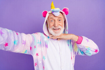 Poster - Self-portrait of handsome trendy cheerful grey-haired man in kigurumi posing fooling isolated on violet purple color background