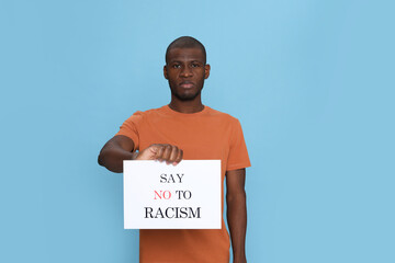 Wall Mural - African American man holding sign with phrase Say No To Racism on light blue background