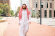 Handsome successful arab man sheikh wearing traditional clothes walking city street in Dubai