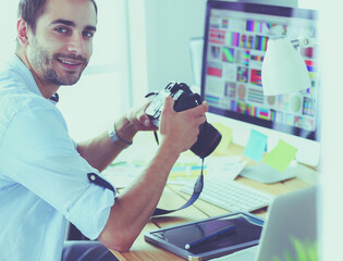 Poster - Portrait of young designer sitting at graphic studio in front of laptop and computer while working online.