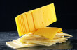 slices of gouda hard cheese on a dark background