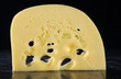 slices of Goudy yellow cheese on black background
