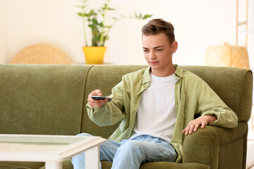 Canvas Print - Teenage boy watching TV on sofa at home