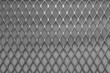 Metal grid with geometric pattern of rhombi, background. Black metallic modern background