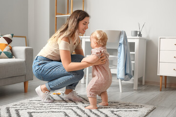 Canvas Print - Cute baby girl in bodysuit learning to walk with mother at home