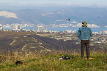 A man looks into glasses and controls a drone with a city view