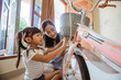 © Odua Images - Togetherness of mother and daughter installing a basket