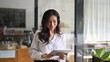 © Prathankarnpap - Smiling asian businesswoman siting in coffee shop and using digital tablet.