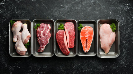 Wall Mural - Set of fresh raw meat and fish in plastic boxes: veal, salmon steak, chicken, pork. Banner for the supermarket. On a dark background. Organic food.