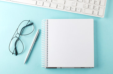 Poster - Keyboard, notebook,pen and glasses on the blue background