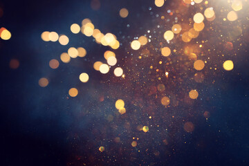 background of abstract glitter lights. gold, blue and black. de focused