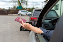 Women Hand Through Car Window Giving Passport For Customs Control, Rear View, Close-up
