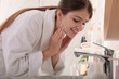 © New Africa - Beautiful teenage girl washing face with water in bathroom