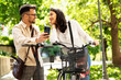 © JustLife - Happy funny couple with bicycle in the park. Loving couple enjoying together outdoors..
