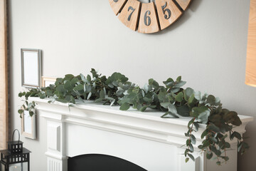 Canvas Print - Beautiful garland with eucalyptus branches on mantelpiece in room