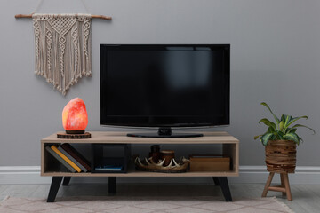 Stylish room interior with TV set, himalayan salt lamp and decor elements